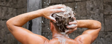 Mand vasker sit hår med skælshampoo