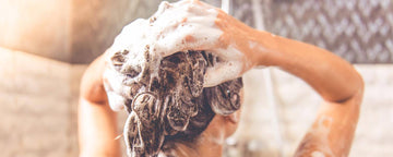 Kvinde bruger en shampoo mod hårtab